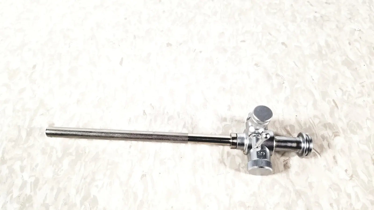 Silver-colored metal laparoscopic obturator with 5 fr instrument featuring complex valve mechanism for reuse medical procedures