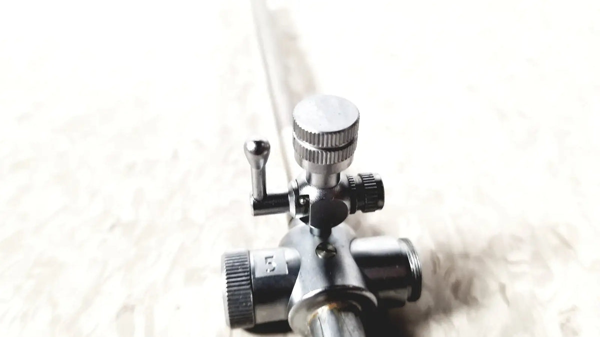 Laparoscopic obturator with 5 fr instrument featuring a silver and black gas regulator with knurled knobs for reuse medical laparoscopic instruments