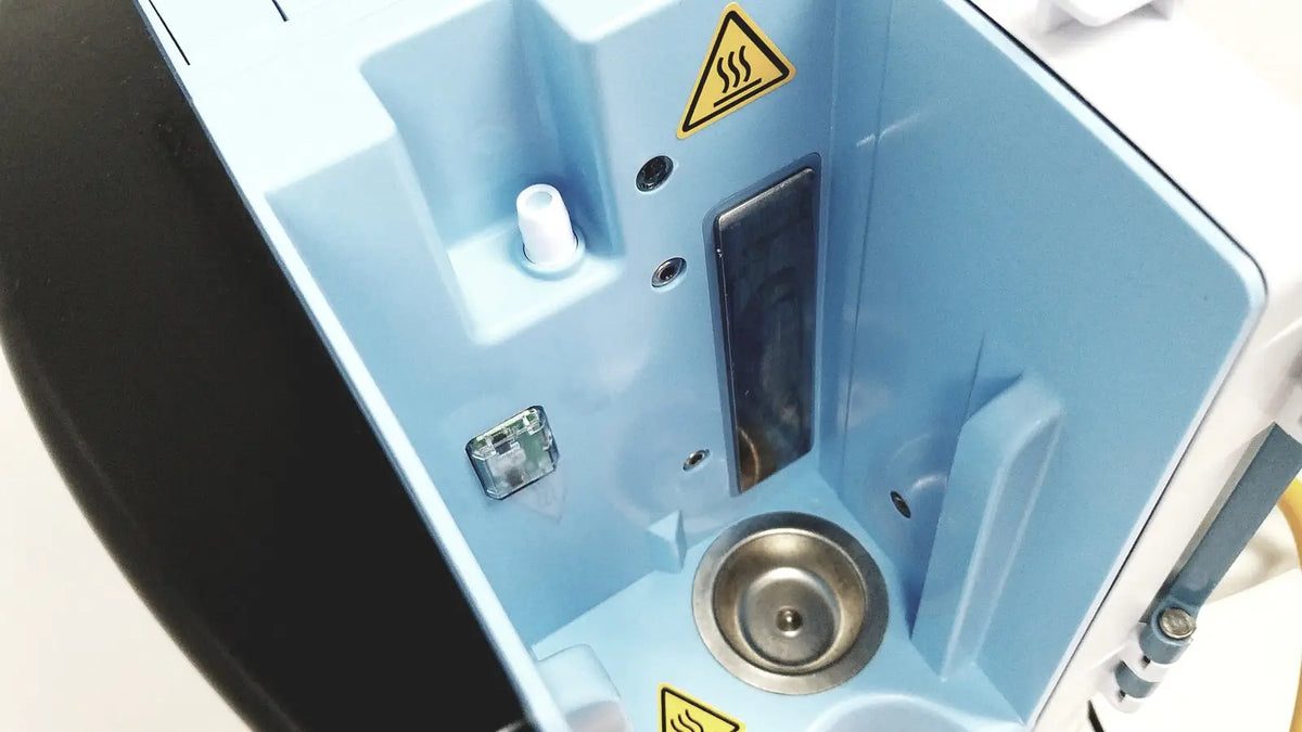 Light blue plastic housing with metallic circular basin and warning labels in leica eg1150h embedding center