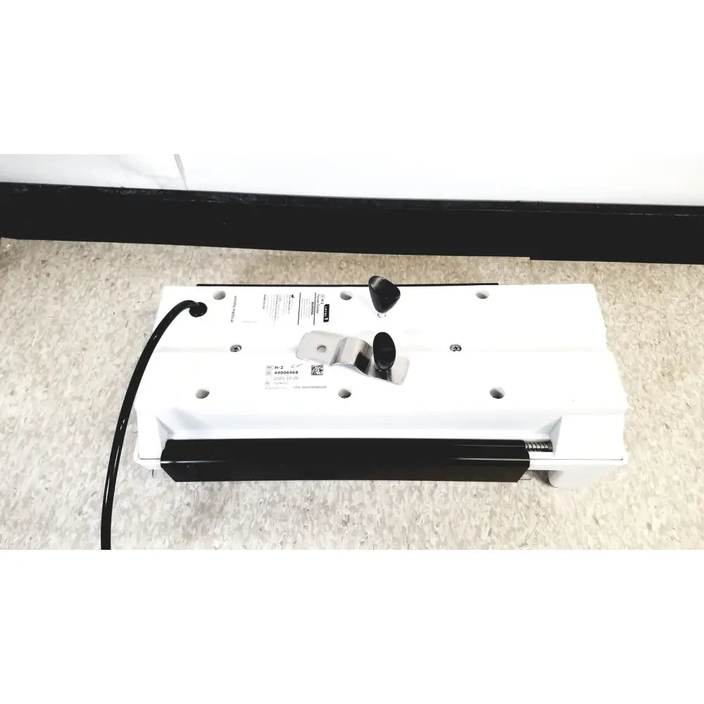 White and black floor cleaning robot with control buttons and charging cable for model h-2 pressure chambers use
