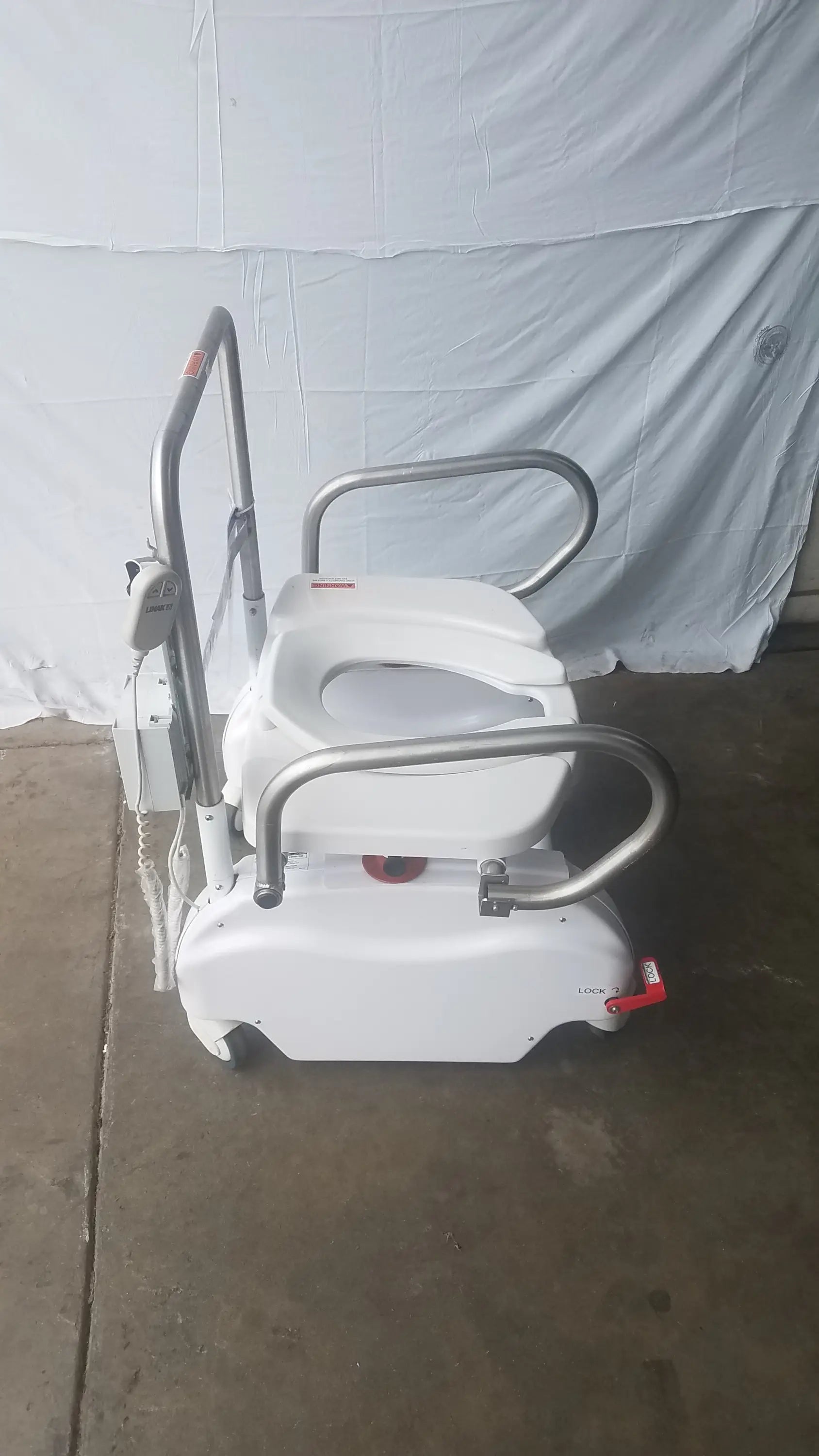 White bariatric power toilet lift with silver metal safety rails and wheels model liftseat ls600 sn ls66011186
