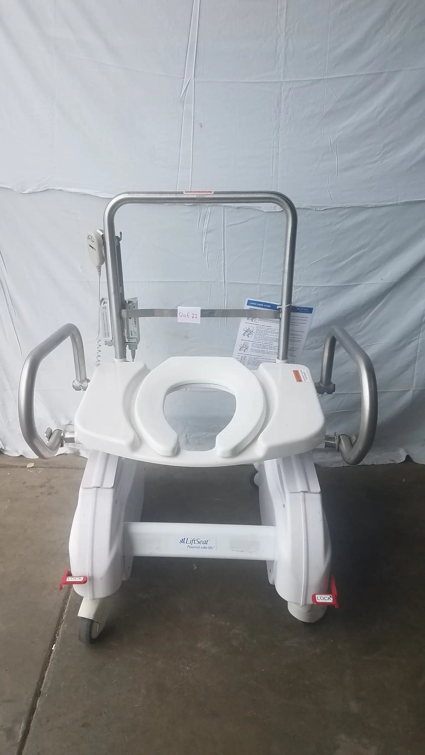 White plastic bariatric power toilet lift chair with silver metal frame handles and four wheels for mobility