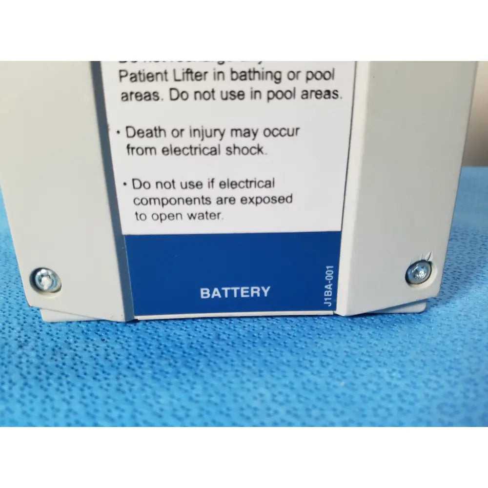 White plastic battery compartment with blue label and safety warnings of linak baj100000011 24v rechargeable battery