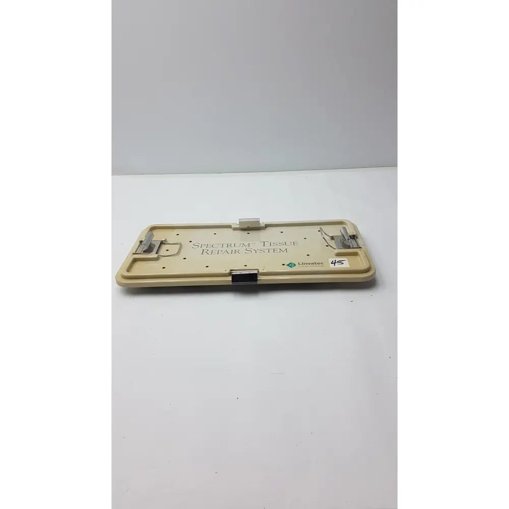 Beige plastic surgical tray with metal clamps and black latch labeled spectrum tissue repair system by linvatec concept arthroscopy
