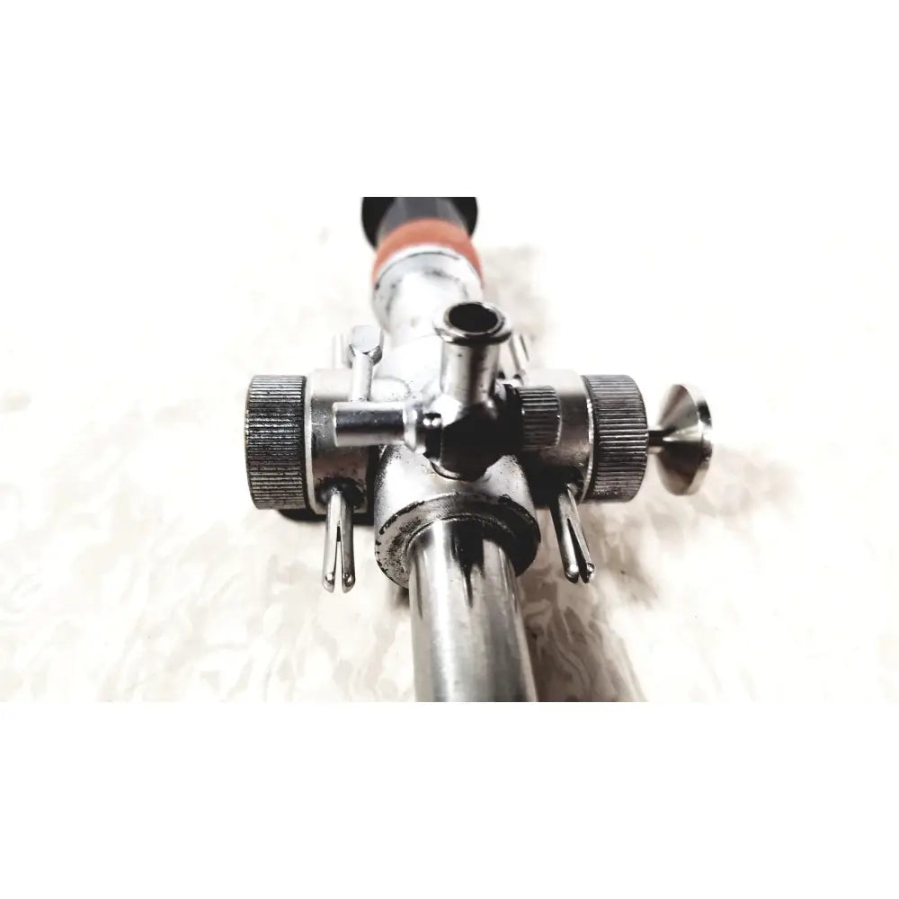 Silver metallic linvatec conmed hasson laparoscopic valve with textured knobs and black-tipped handle for surgery