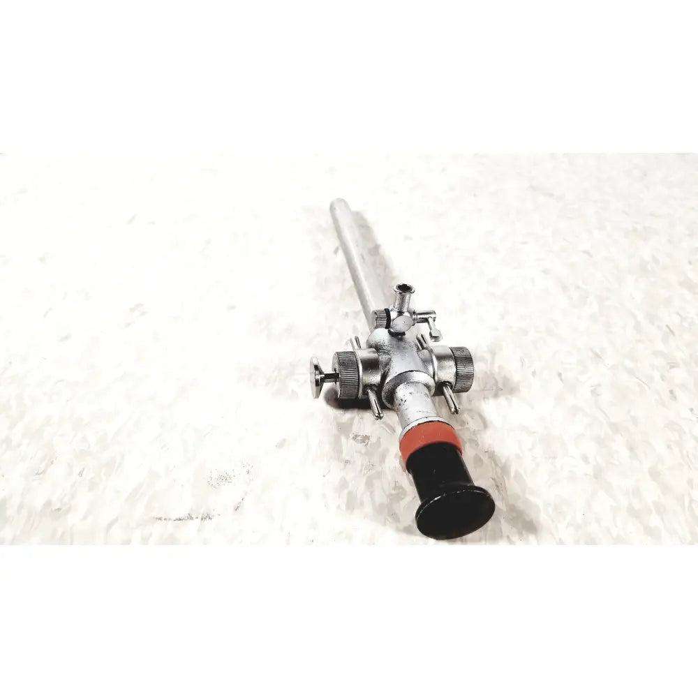 Silver-colored linvatec conmed hasson laparoscopic valve with black handle red accent and multiple control knobs ports