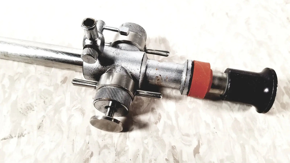 Silver metallic linvatec conmed 118100 hasson laparoscopic valve with black handle and red accent ring surgical instrument