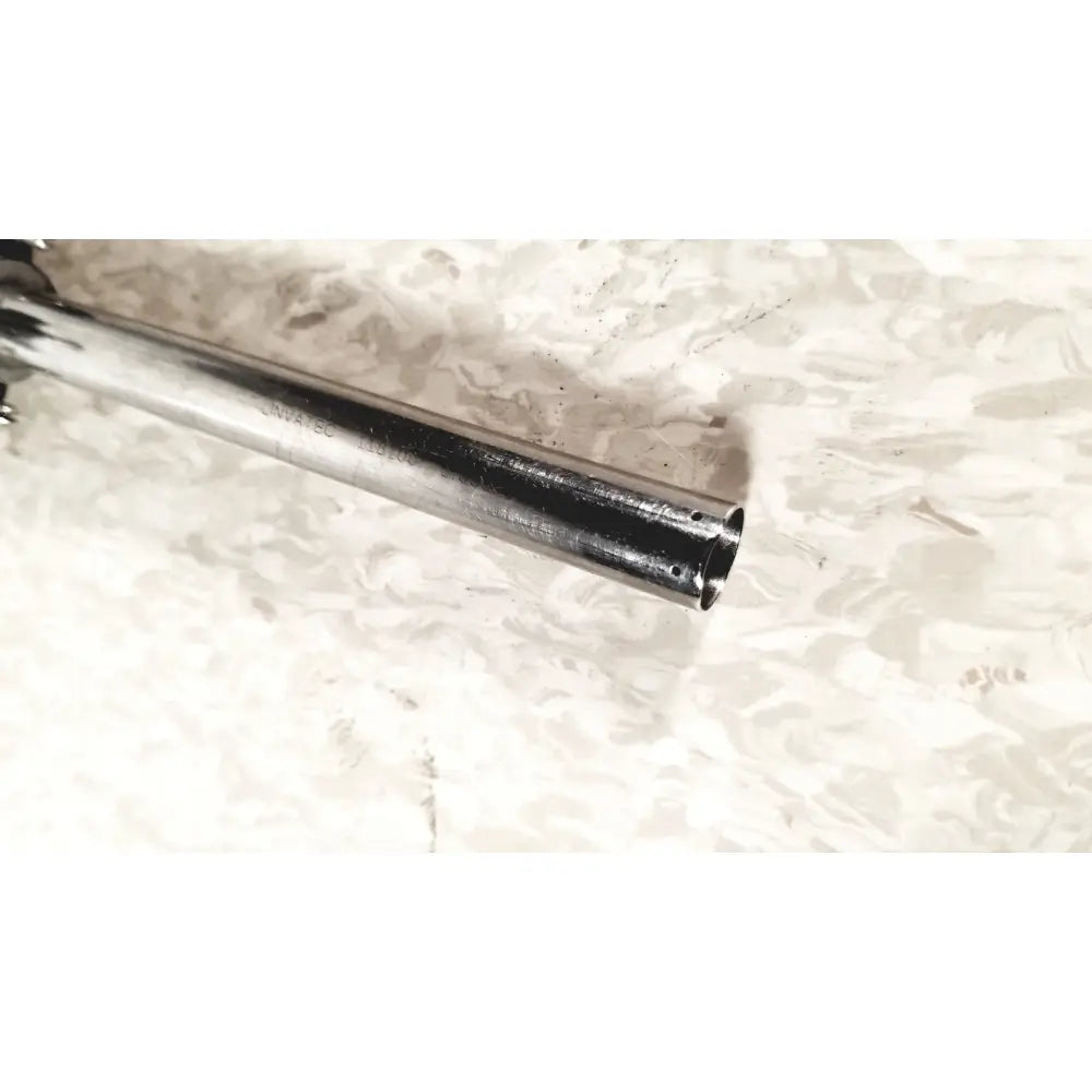 Shiny chrome-finished metal linvatec conmed laparoscopic valve with engraved markings and worn darkened interior for reuse medical use