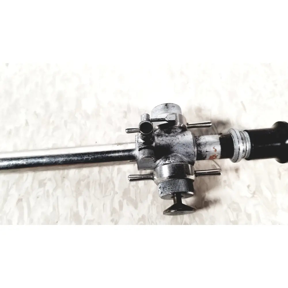 Silver and black linvatec conmed 118100 laparoscopic valve with adjustable knobs and connectors for laparoscopic instruments