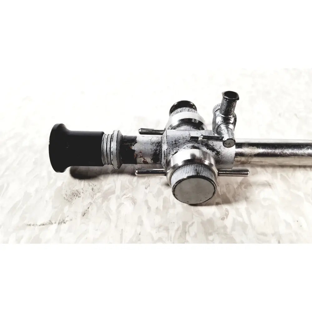 Silver-toned linvatec conmed laparoscopic valve with black rubber eyepiece and multiple metallic control knobs for laparoscopic instruments