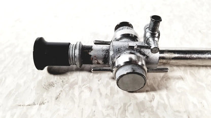 Silver-toned linvatec conmed laparoscopic valve with black rubber eyepiece and multiple metallic control knobs for laparoscopic instruments