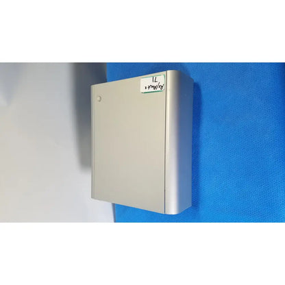 Silver metallic wall-mounted utility box with circular latch and handwritten label on lonza 4d-nucleofector x unit back side