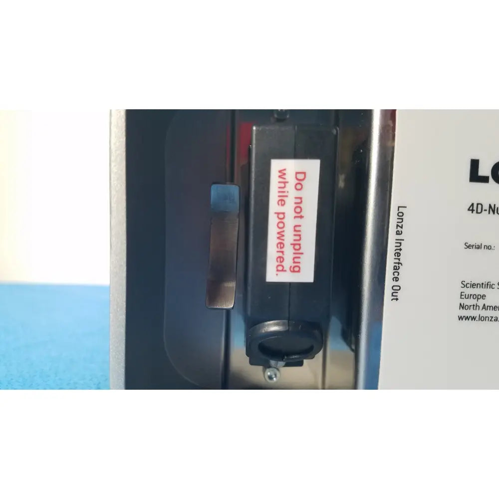 Black rectangular Lonza 4d-nucleofector x unit with metallic handle and white do not unplug warning label for reuse medical use