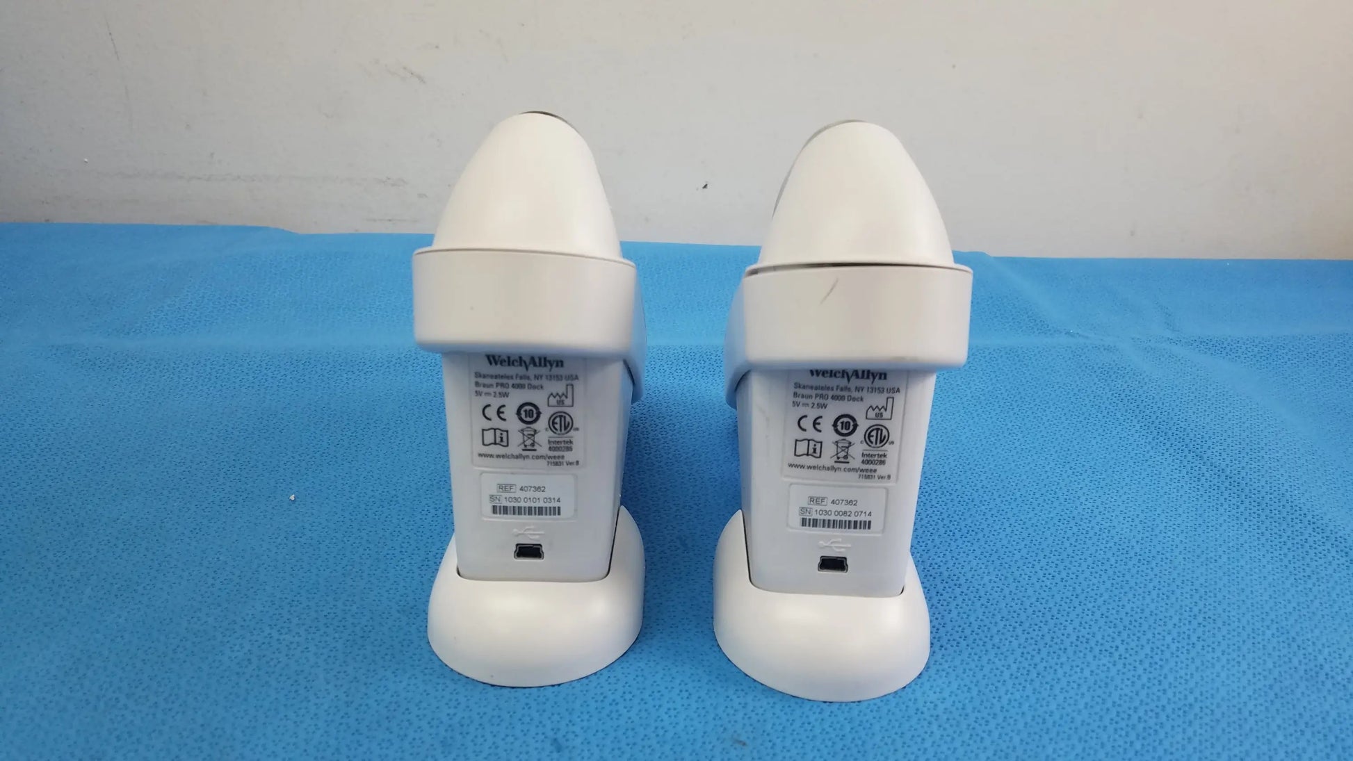 Two white welch allyn medical devices shown from the back with printed labels in a lot of 2 braun pro 4000 thermoscan reuse medical equipment