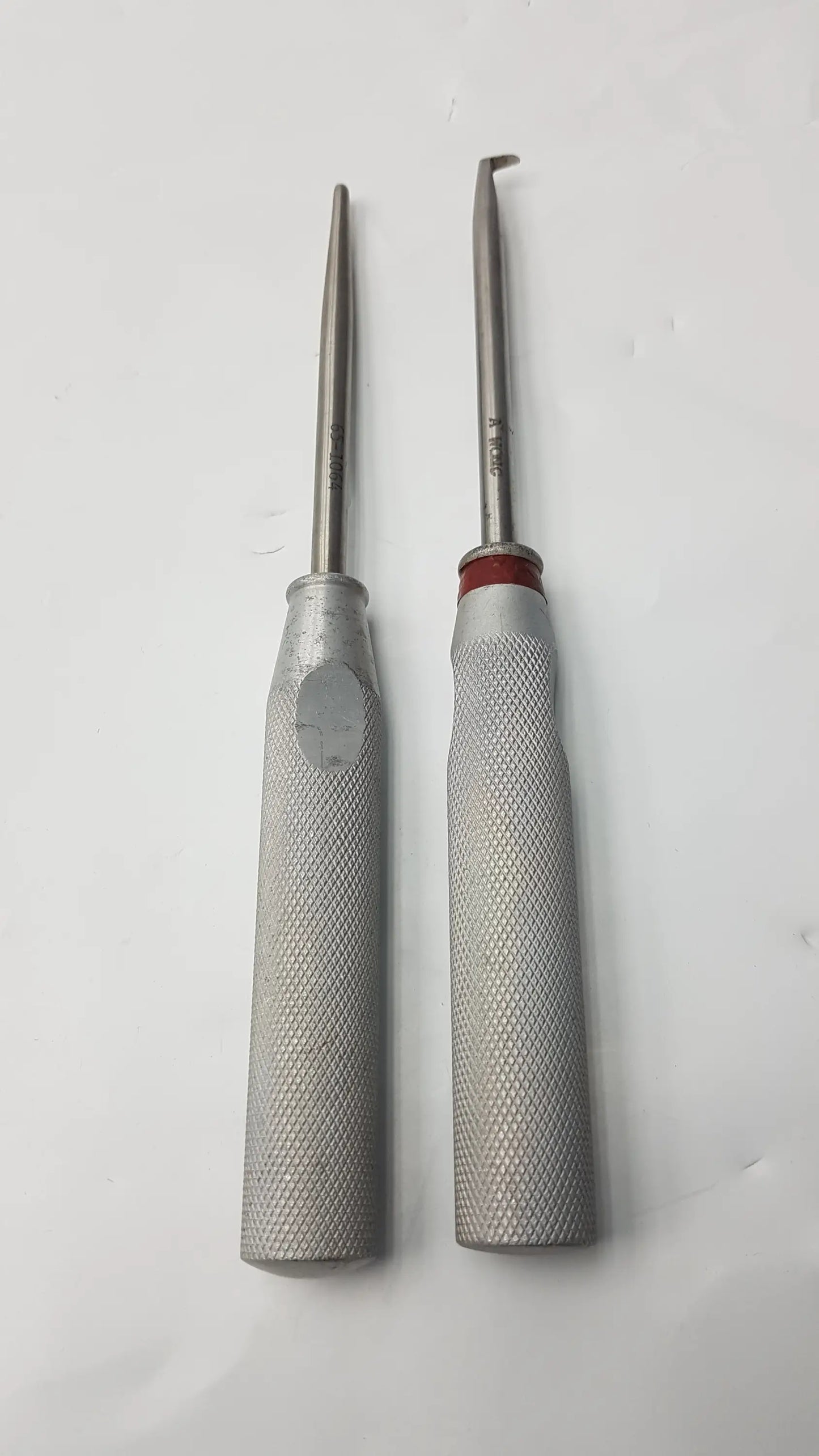 Lot of 2 codman 8710n osteophyte metallic orthopedic surgical elevators with textured silver handles and red accents