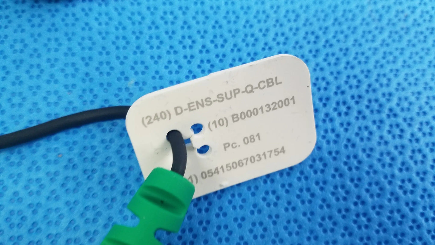 White rectangular label with serial numbers and green connector on black cable for reuse medical equipment use