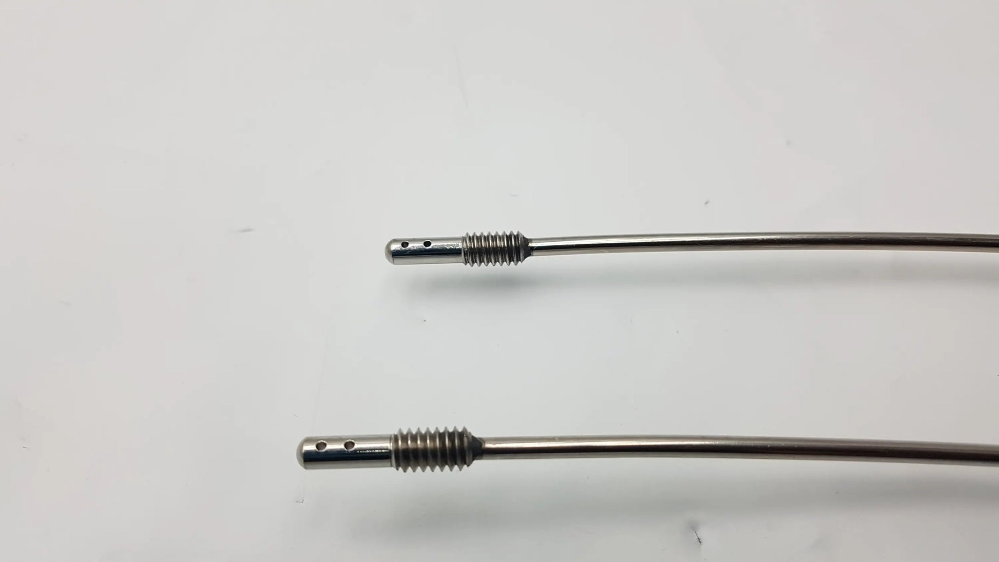 Two slender metallic gore tunnelers with threaded ends featuring slight curve long and full curve long designs