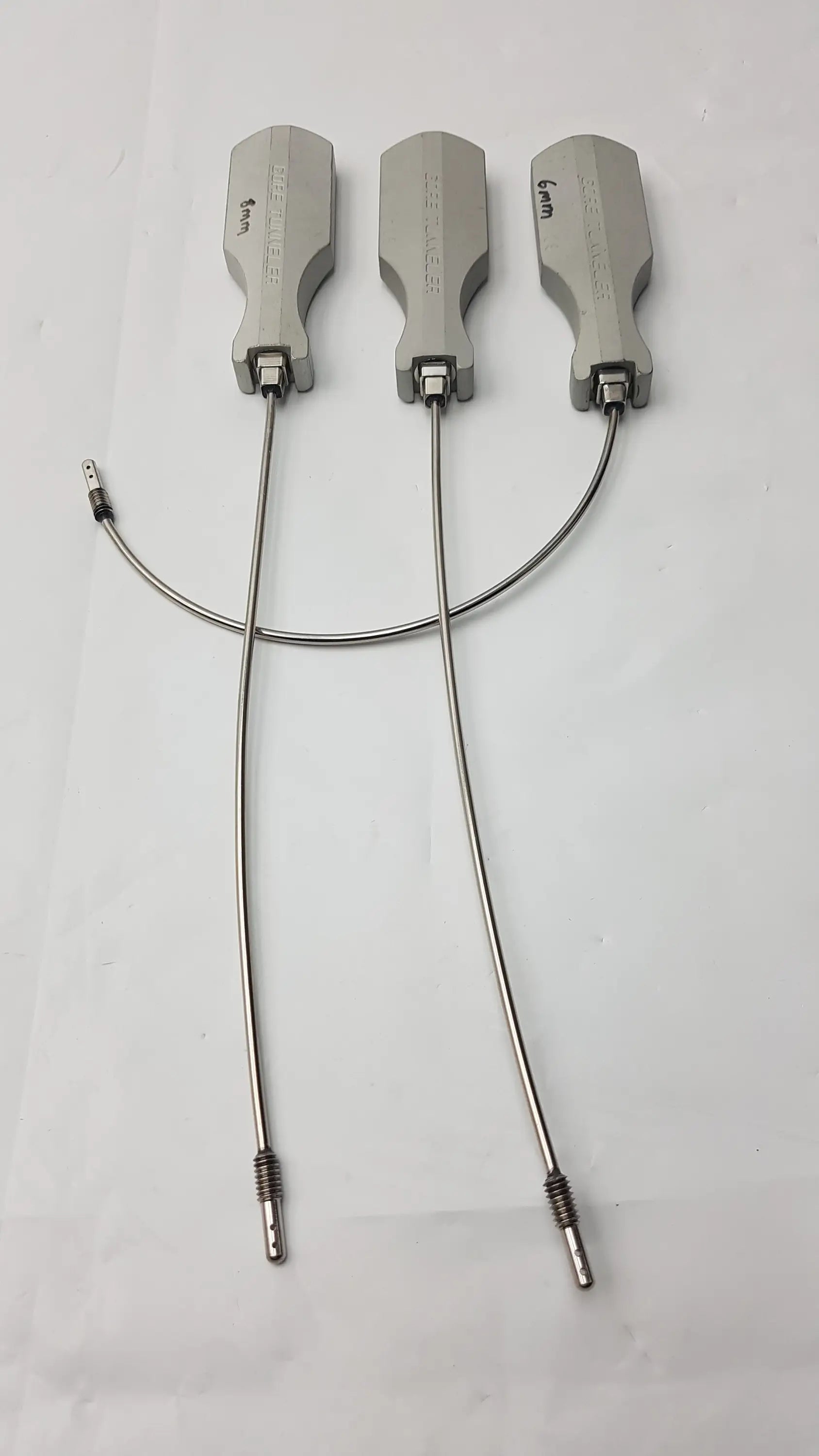 Three silver-colored gore tunneler surgical retractors with engraved markings and flexible metal arms slight curve long