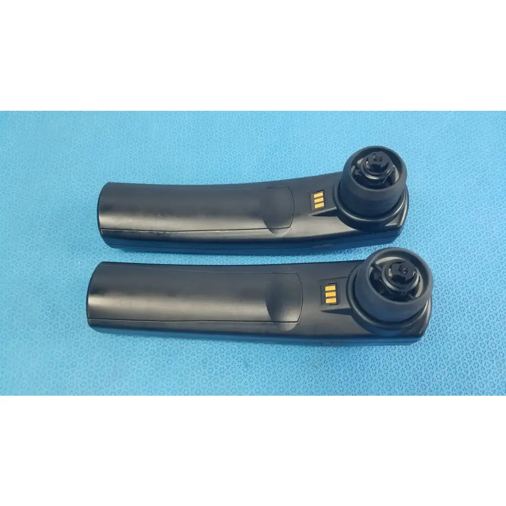 Black plastic car door handle remote key fob with gold contacts and circular button housing for handheld auditory use