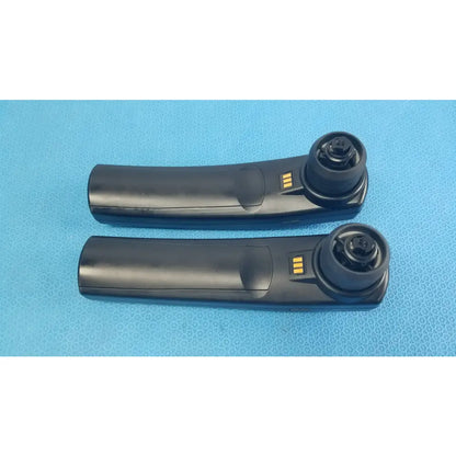 Black plastic car door handle remote key fob with gold contacts and circular button housing for handheld auditory use