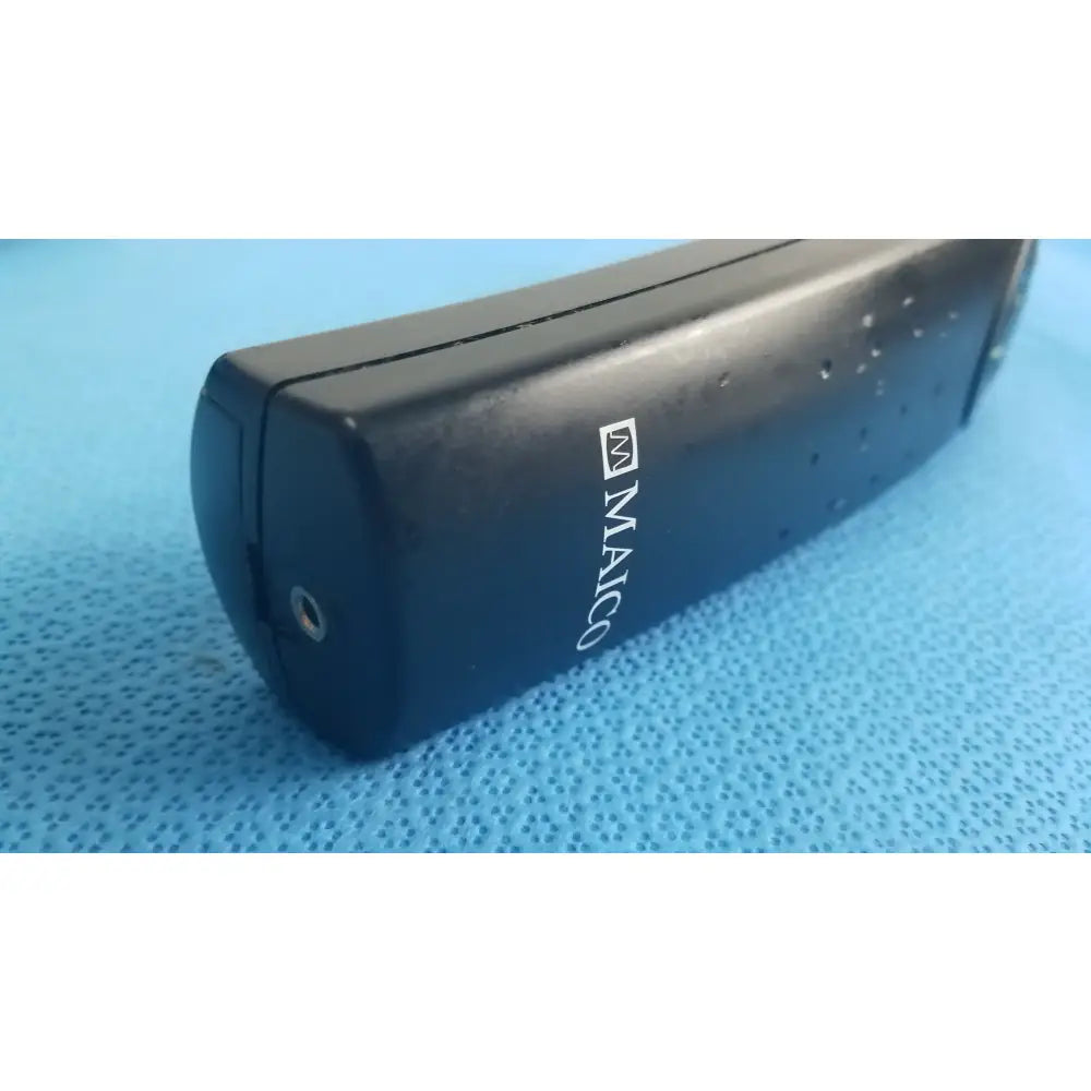 Black maico branded portable charger with matte finish and side perforations for handheld auditory medical equipment