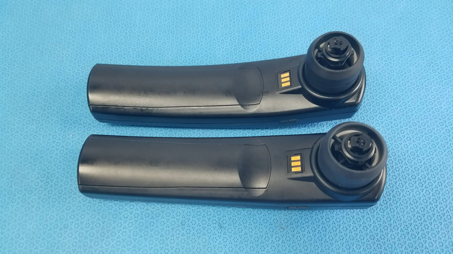 Black plastic car door handle remote key fob with gold contacts and circular button housing for handheld auditory use