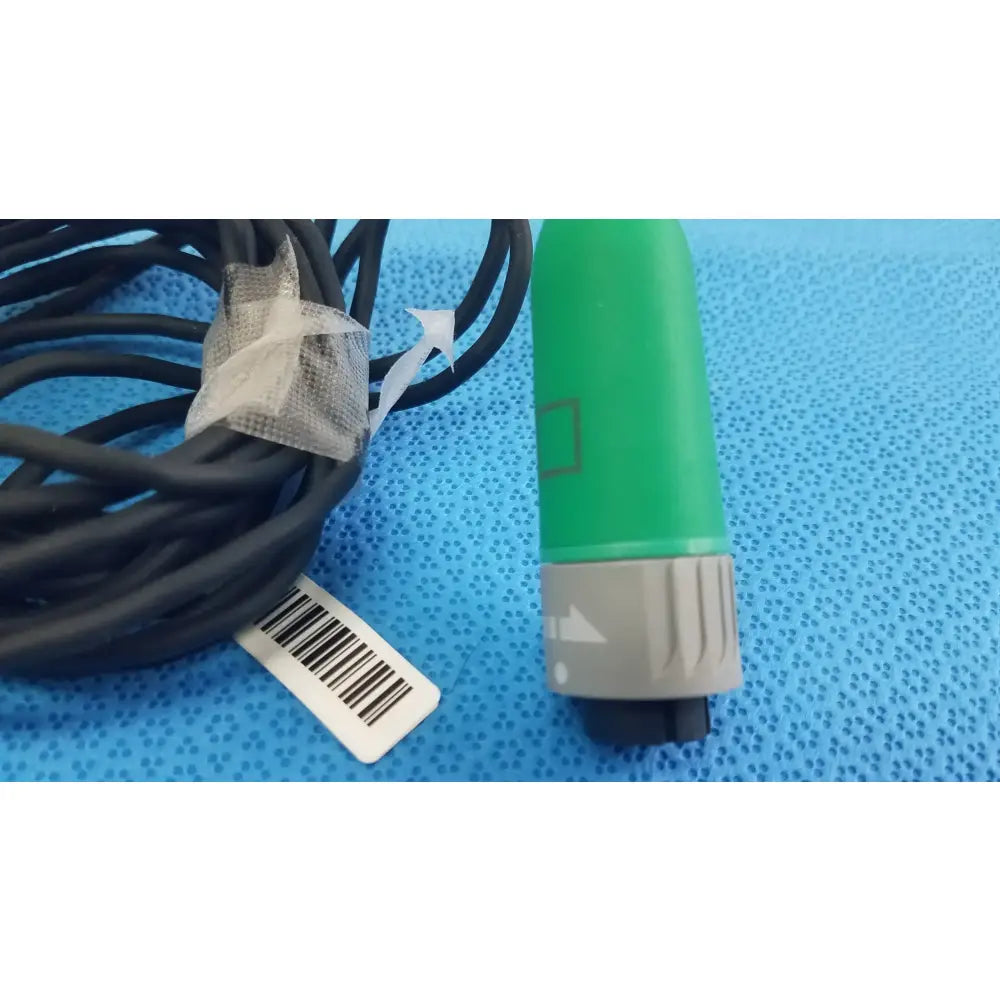 Green and gray fiber optic stryker catheter connector with black cable coiled for reuse medical equipment use
