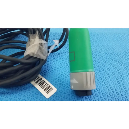 Green and gray fiber optic stryker catheter connector with black cable coiled for reuse medical equipment use