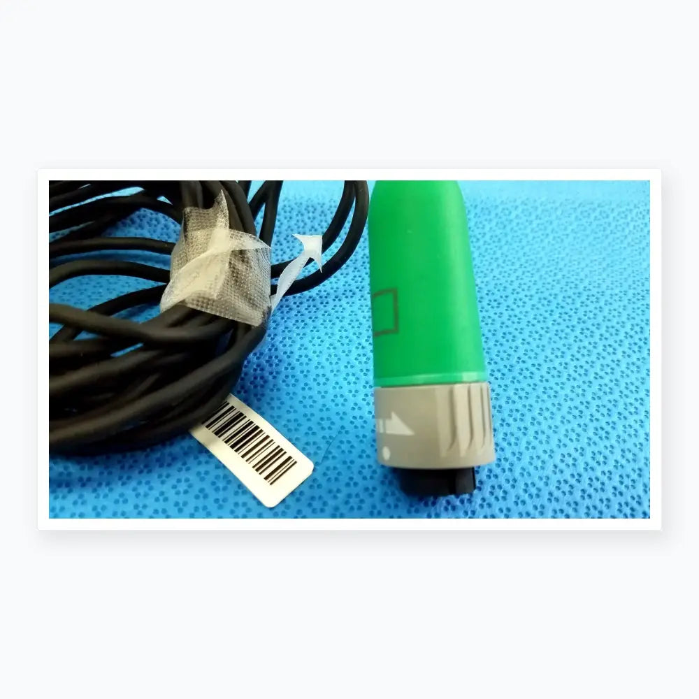 Green and gray fiber optic stryker catheter connector with black cable coiled for reuse medical equipment use