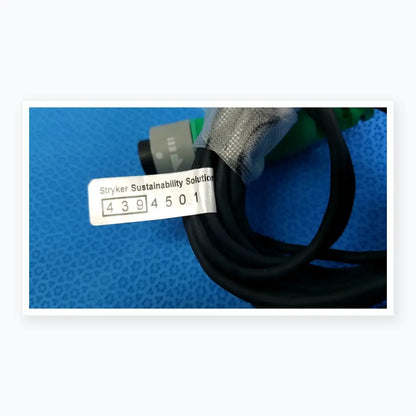 Lot of 2 black coiled stryker catheter connector cables with gray stryker sustainability solution label for medical equipment reuse