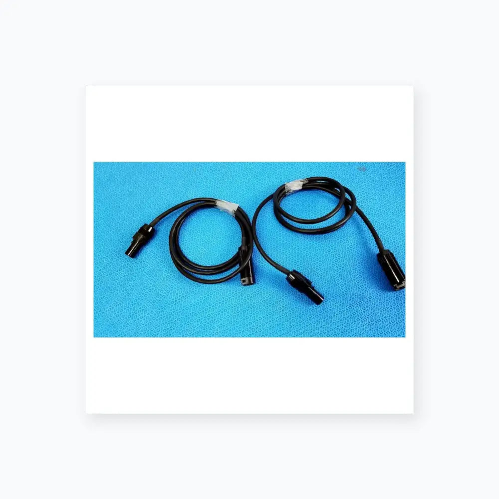 Lot of 3 black coiled mc4 solar connector extension cables with plastic connectors and white tape wraps for pv systems