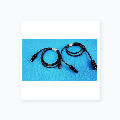 Lot of 3 black coiled mc4 solar connector extension cables with plastic connectors and white tape wraps for pv systems