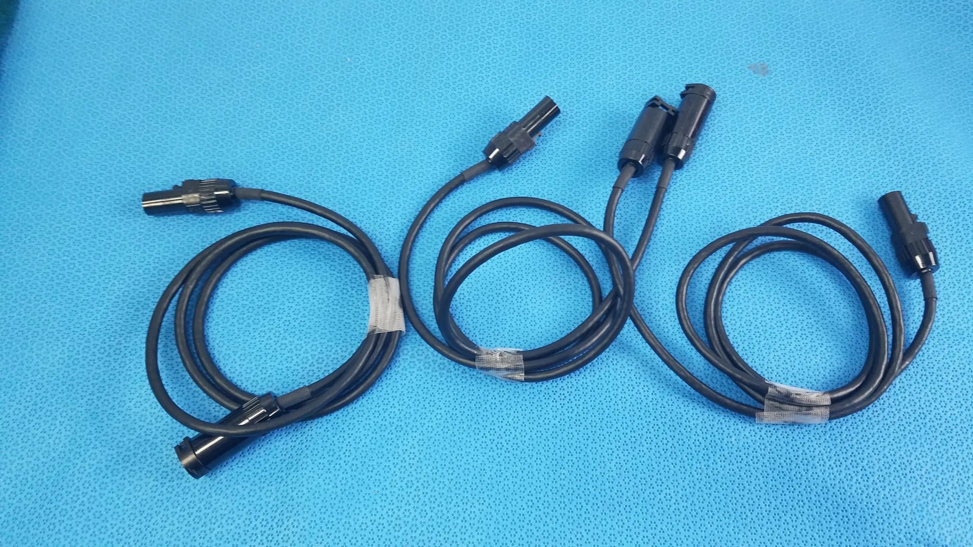 Lot of 3 black mc4 solar connector extension cables with metallic connectors secured by clear plastic ties for photovoltaic use