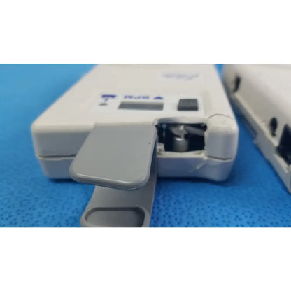 White plastic Natus Neurology Elite 200R handheld Doppler with gray hinged cover showing internal components medical equipment