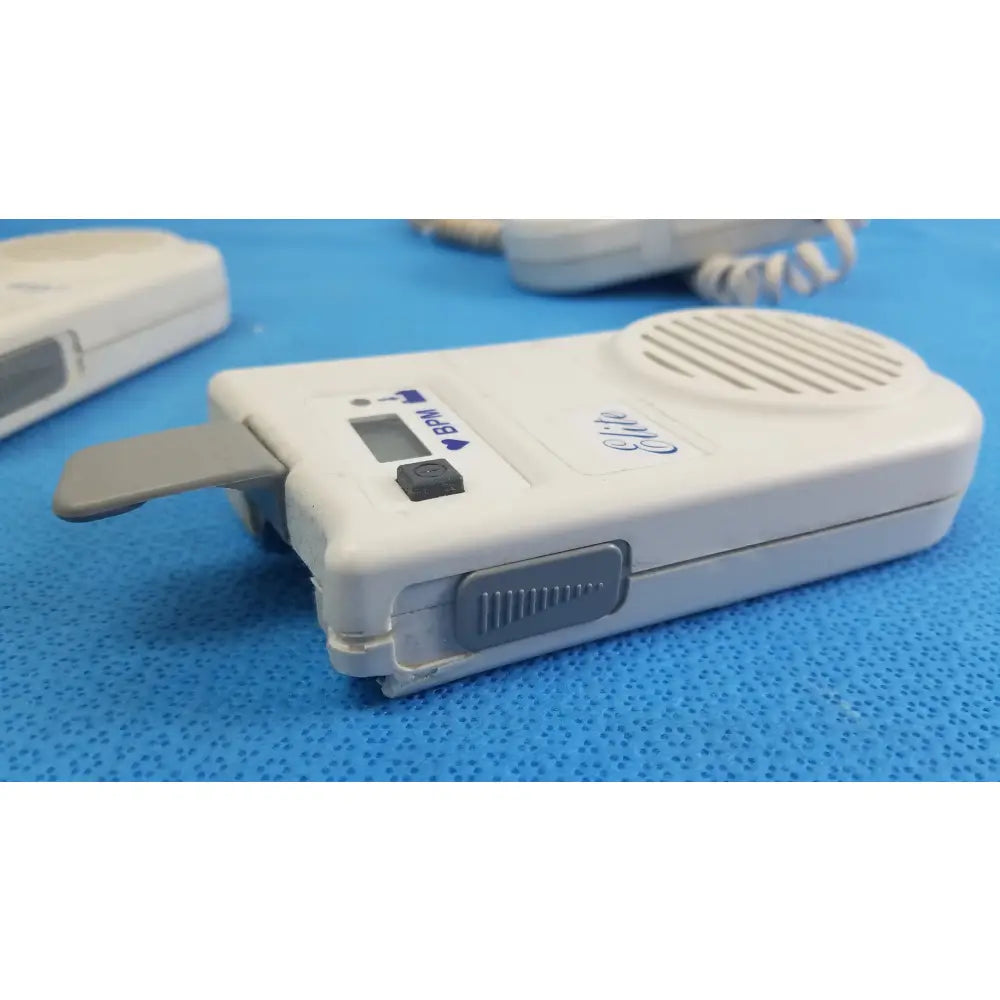 White plastic oricom handheld intercom with gray accents and small digital display in lot of 3 natus neurology elite medical equipment