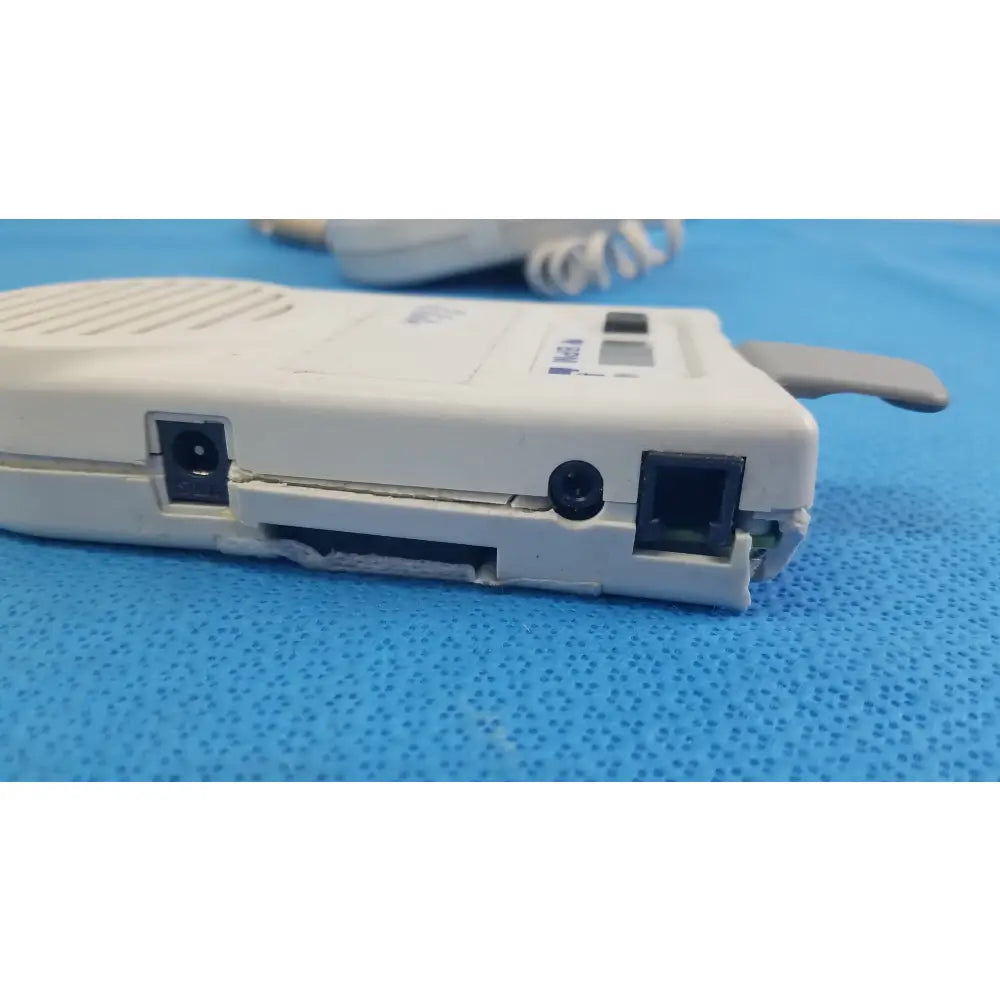 White plastic handheld doppler with pink label and gray mesh, natus neurology elite 200r medical equipment for reuse