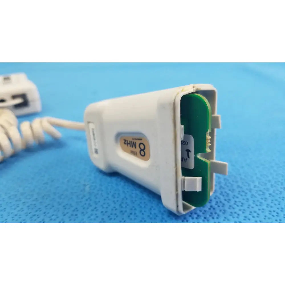 White plastic handheld doppler with green circuit board labeled 8 mhz for reuse medical equipment natus neurology elite