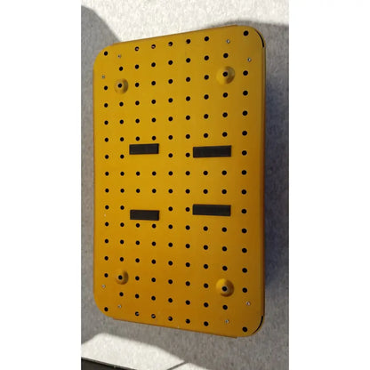 Bright yellow metal diffuser housing perforator driver with grid holes and four black rectangular strips empty case only