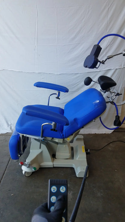 Magstim tms therapy chair with blue upholstery, articulating arm, stimulation coil, adjustable armrests, and beige metal base
