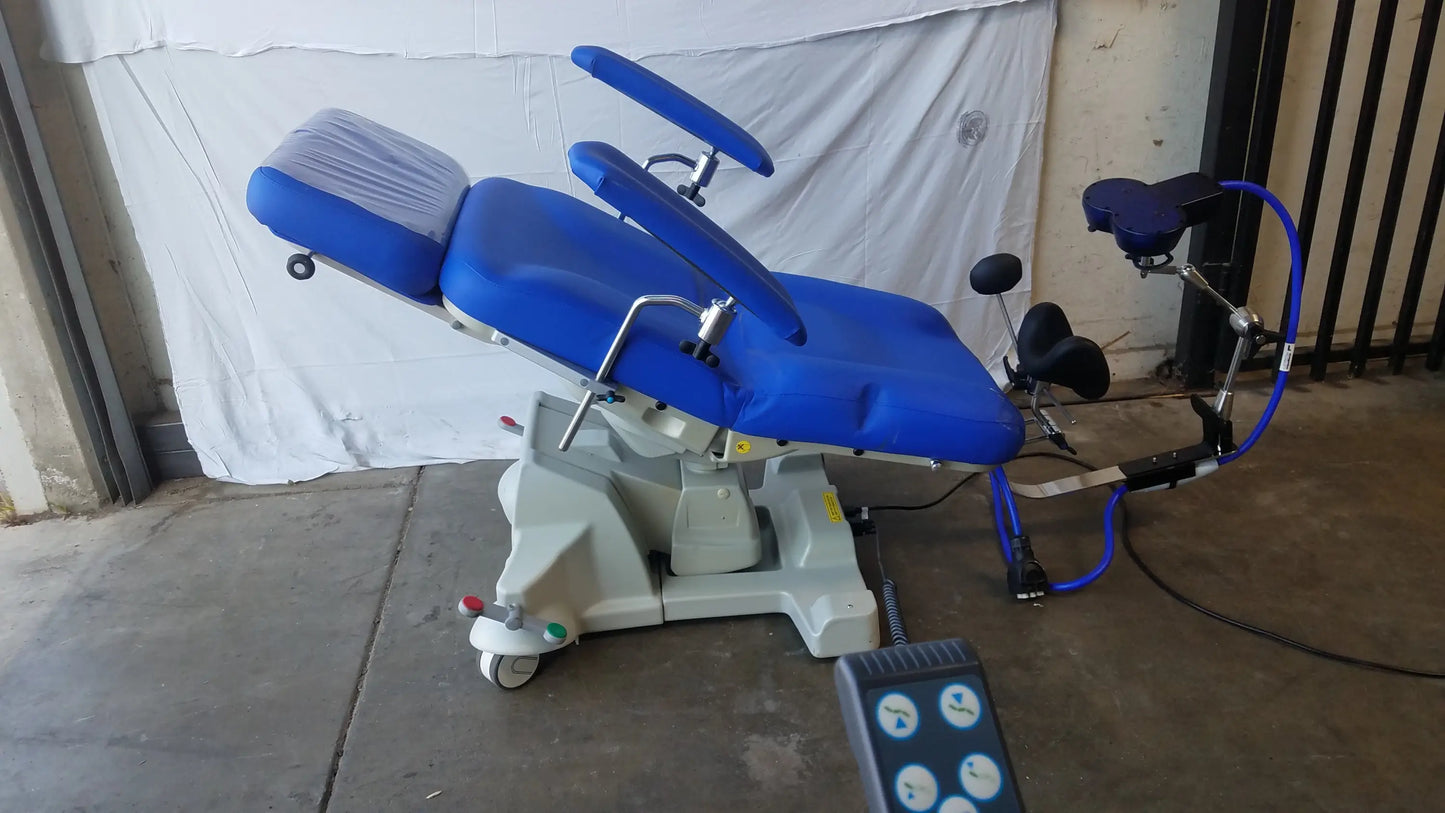Blue padded magstim tms therapy chair with articulating arm, stimulation coil, adjustable armrests, and wheeled base