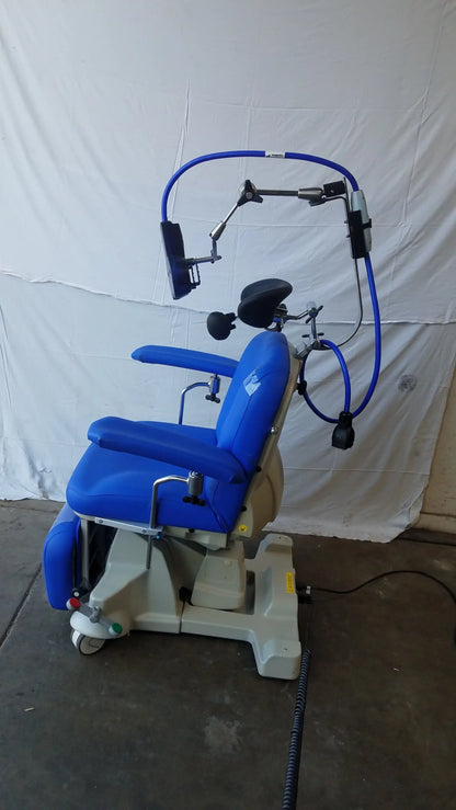 Blue Magstim therapy chair with adjustable headrest and articulating arm holding stimulation coil and monitor