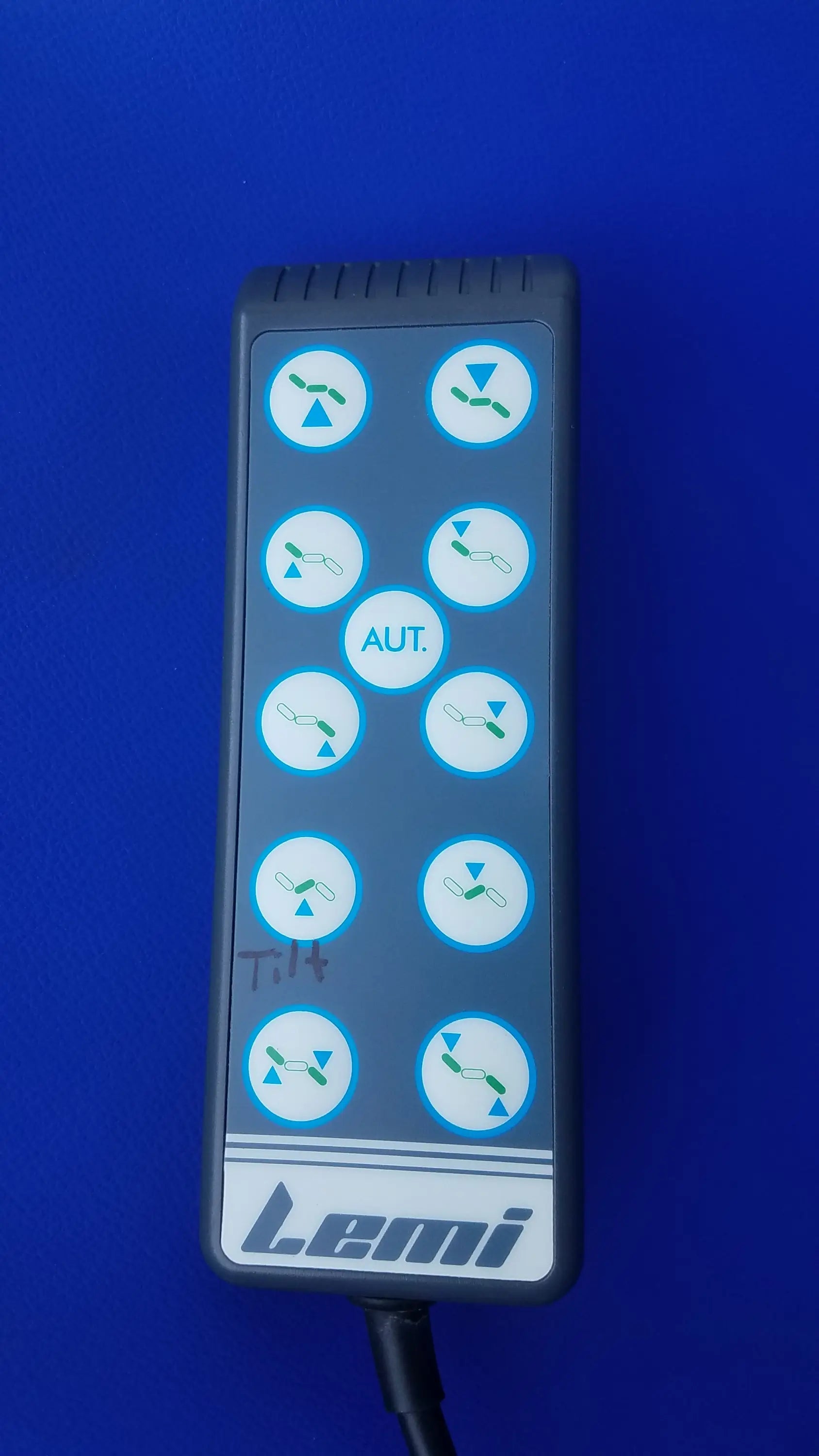 Gray lemi brand remote control with circular green and white buttons for magstim tms therapy chair with articulating arm and stimulation coil