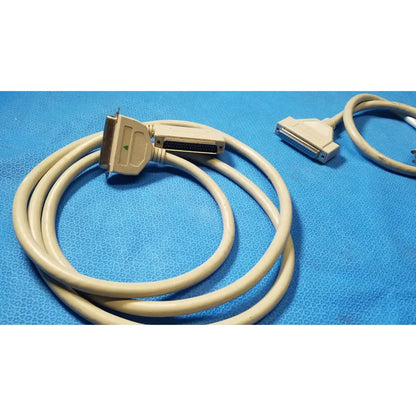 Beige coiled male to female extension cable with db-25 connectors and green arrow indicator for female extension use