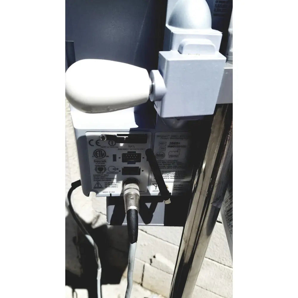White plastic handle attached to gray masimo mridium 3600 plus mri infusion pump monitoring system with certification labels