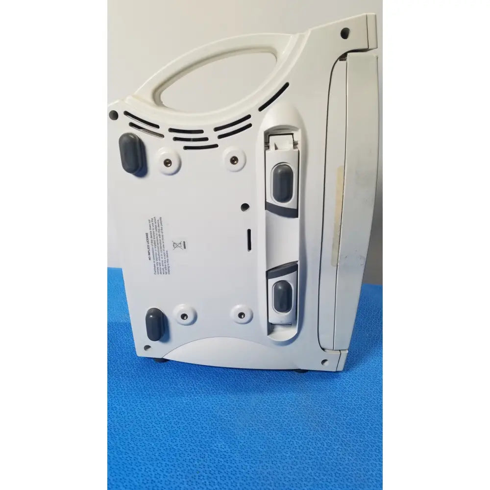 Masimo radical signal extraction pulse oximeter laptop in white plastic with black rubber feet and back handle shown from rear