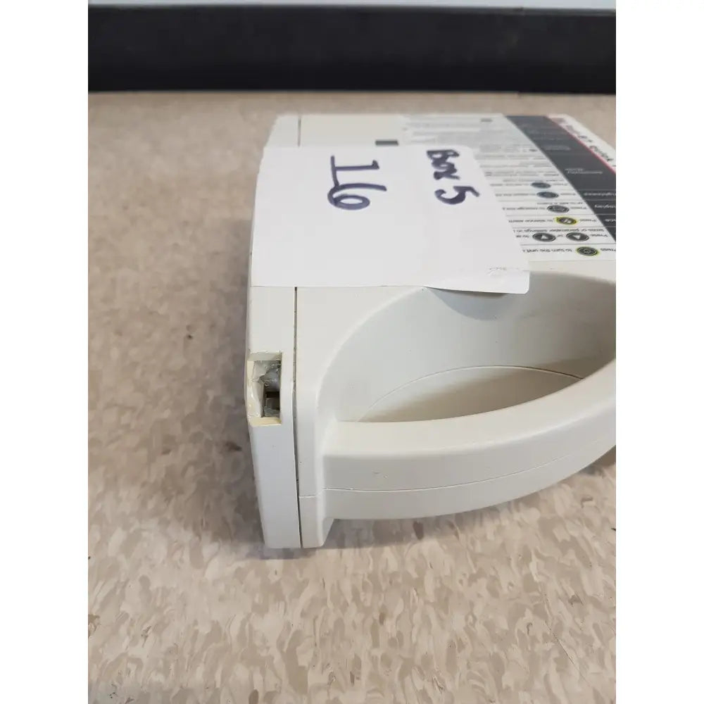 White plastic medical masimo set rainbow pulse oximeter with curved handle and labeled control panel for monitoring