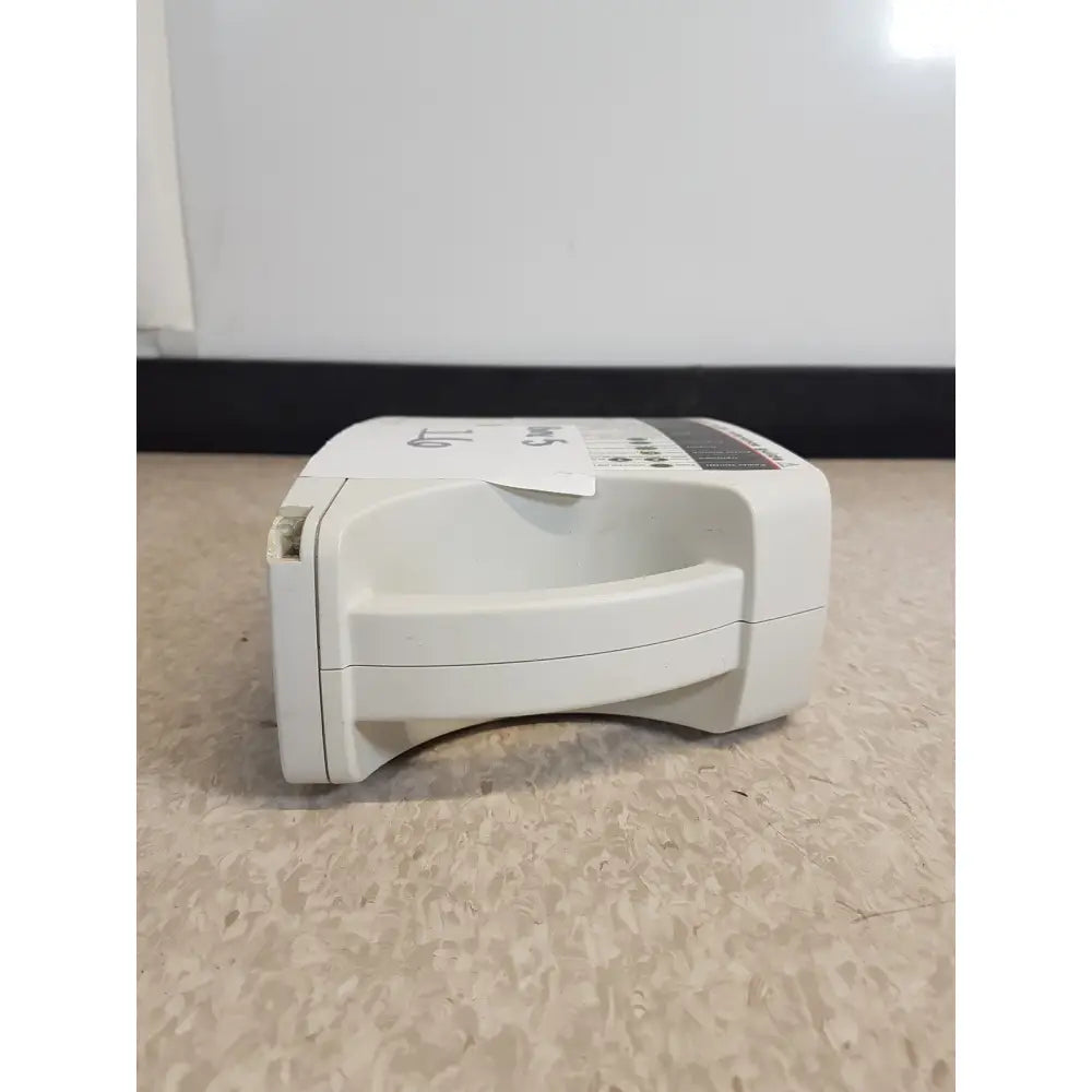White plastic AED device with handle and control panel in Masimo Set Rainbow RAD 87 pulse oximeter monitor