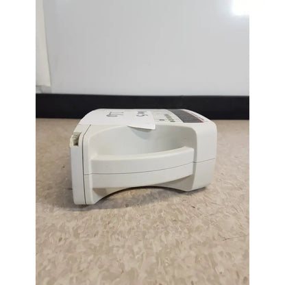 White plastic AED device with handle and control panel in Masimo Set Rainbow RAD 87 pulse oximeter monitor