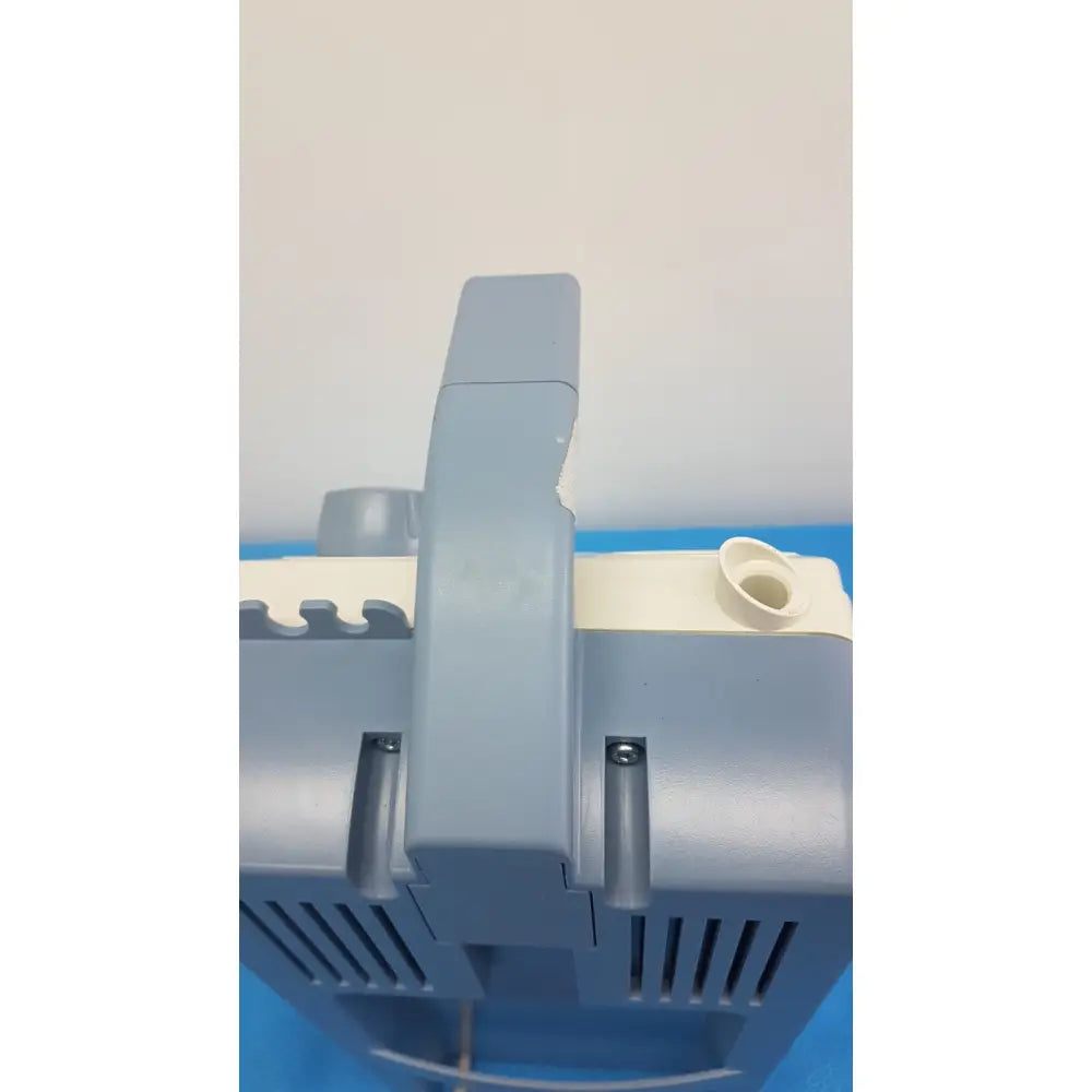 Gray plastic medela vario suction pump aspirator with handle and ventilation slots for portable medical use