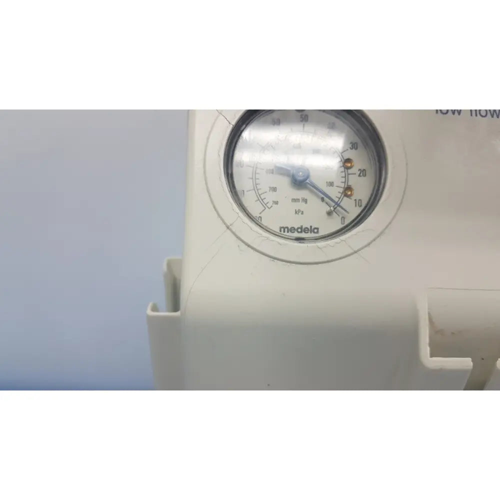 White medela vario suction pump aspirator with circular pressure gauge and blue needle for portable medical use